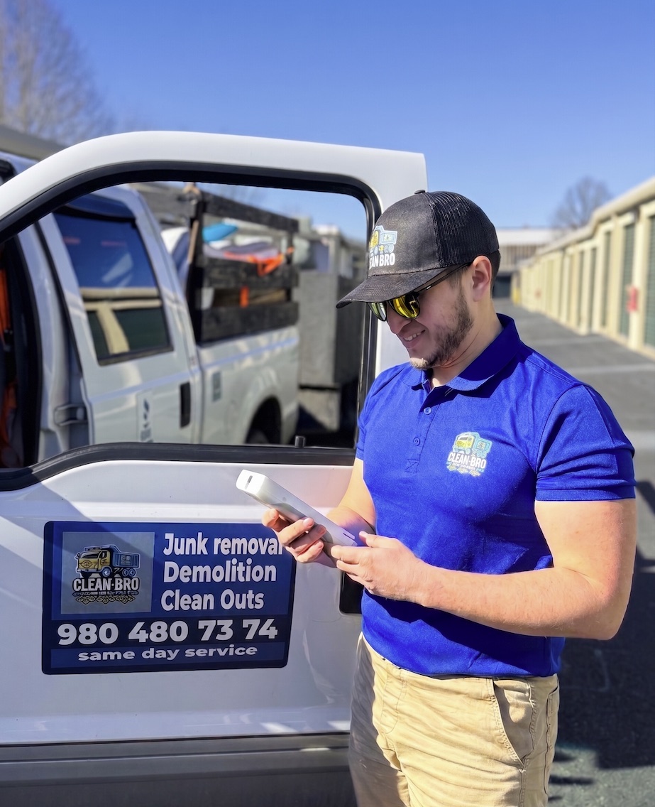 CleanBroServices team member checking a phone beside the branded work truck.
