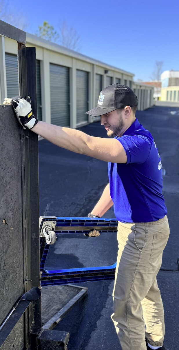 CleanBroServices team member loading equipment beside a storage facility